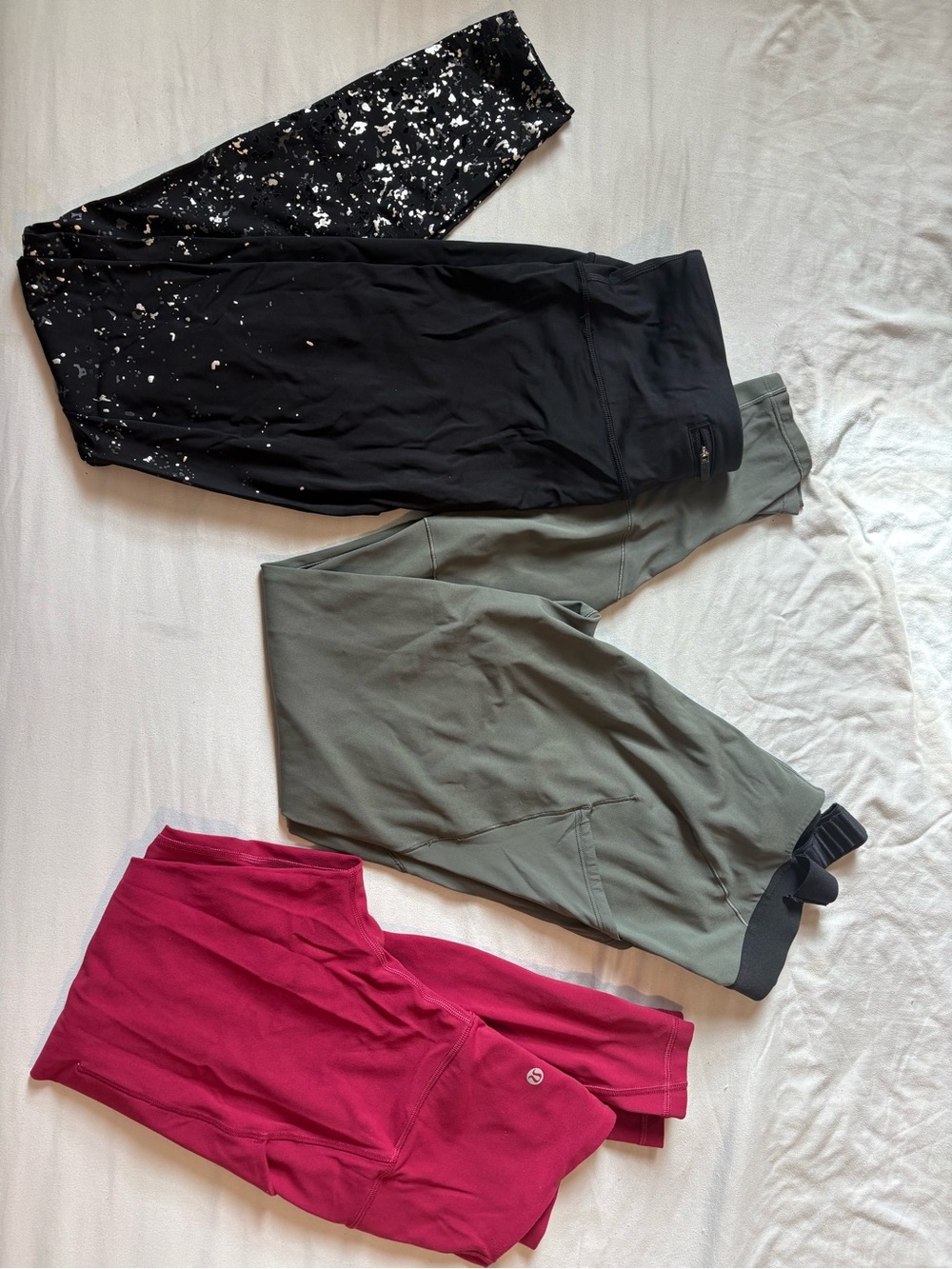 lululemon athletica leggings trio in black splatter, olive green, and cranberry